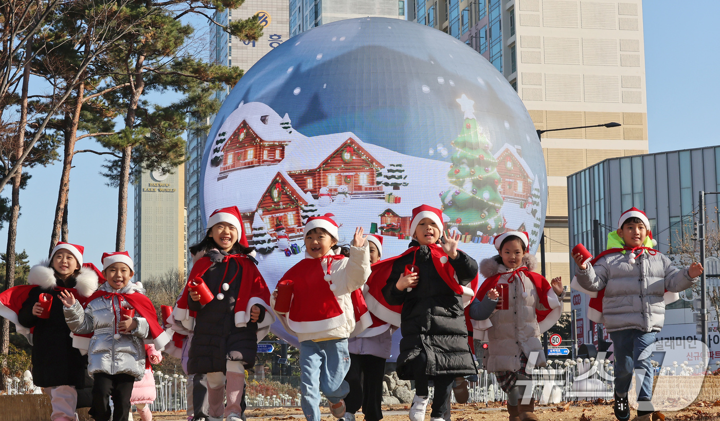 (서울=뉴스1) 장수영 기자 = 산타 복장을 차려입은 송파구청 어린이집 아이들이 18일 오전 서울 송파구 석촌호수 더 스피어에서 놀이를 하고 있다.송파구는 연말연시를 맞아 더 스피 …