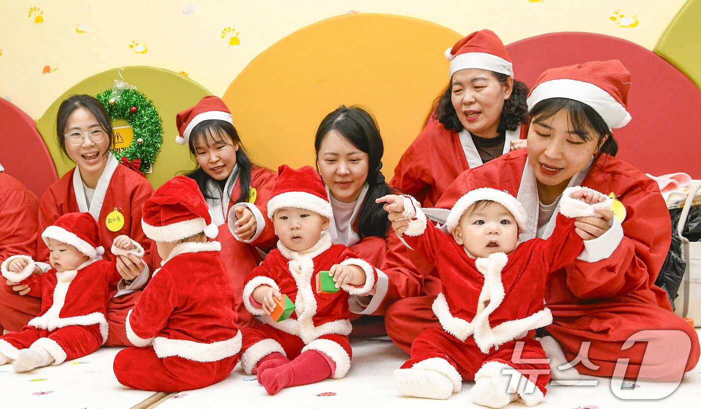 본문 이미지 - 크리스마스를 일주일 앞둔 18일 경기 광주시 능평도서관에서 산타 복장을 입은 엄마와 아기들이 놀이를 하고 있다. (공동취재) 2025.12.18/뉴스1 ⓒ News1 김영운 기자