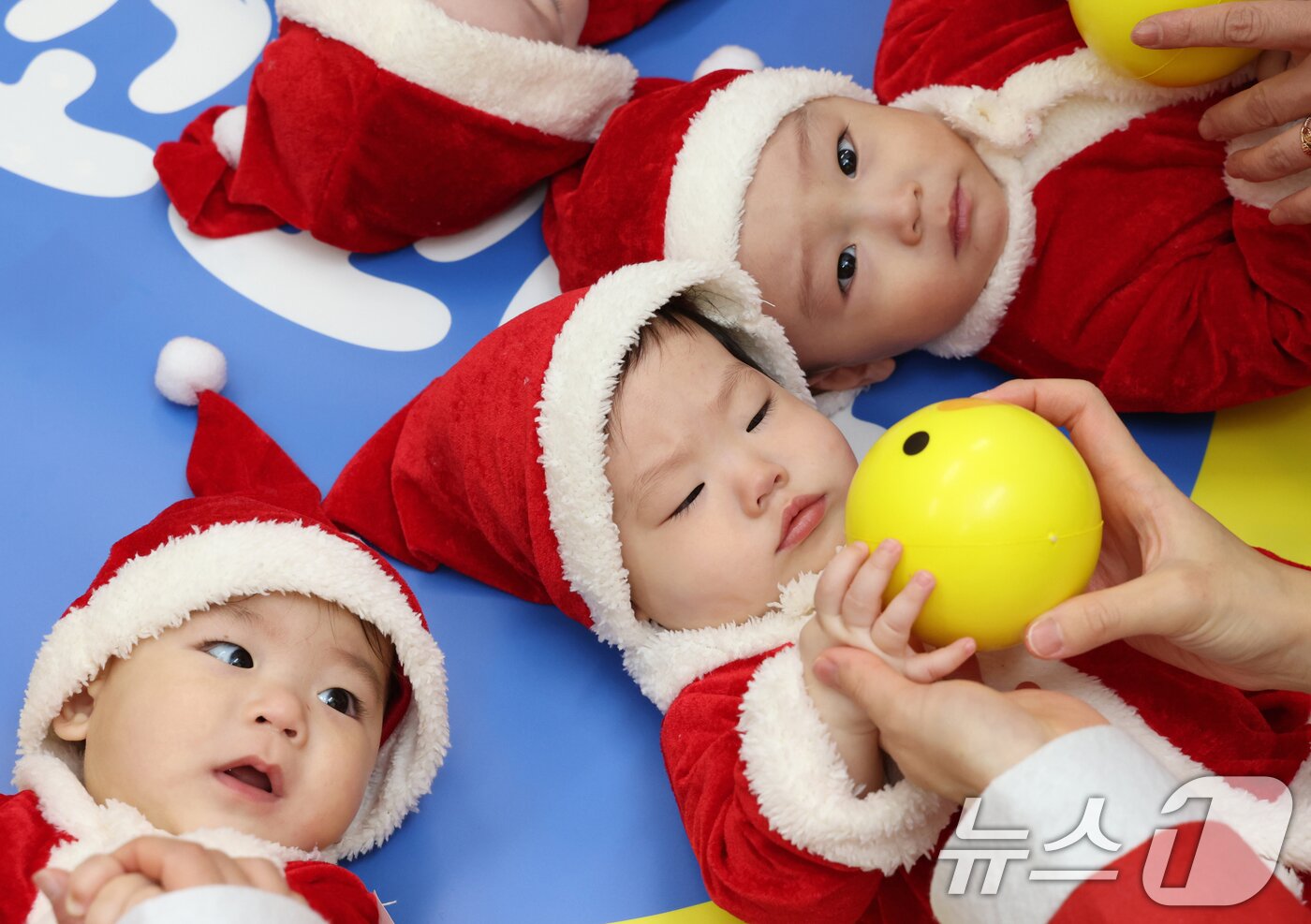 본문 이미지 - 크리스마스를 일주일 앞둔 18일 경기 광주시 능평도서관에서 산타 복장을 입은 엄마와 아기들이 놀이를 하고 있다. (공동취재) 2025.12.18/뉴스1 ⓒ News1 김영운 기자