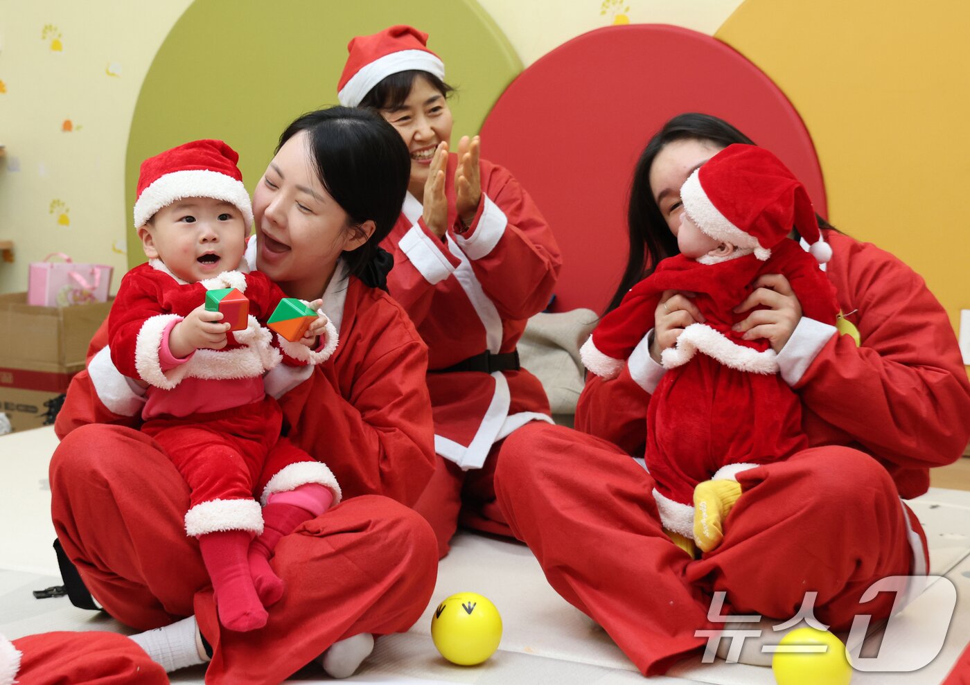본문 이미지 - 크리스마스를 일주일 앞둔 18일 경기 광주시 능평도서관에서 산타 복장을 입은 엄마와 아기들이 놀이를 하고 있다. (공동취재) 2025.12.18/뉴스1 ⓒ News1 김영운 기자