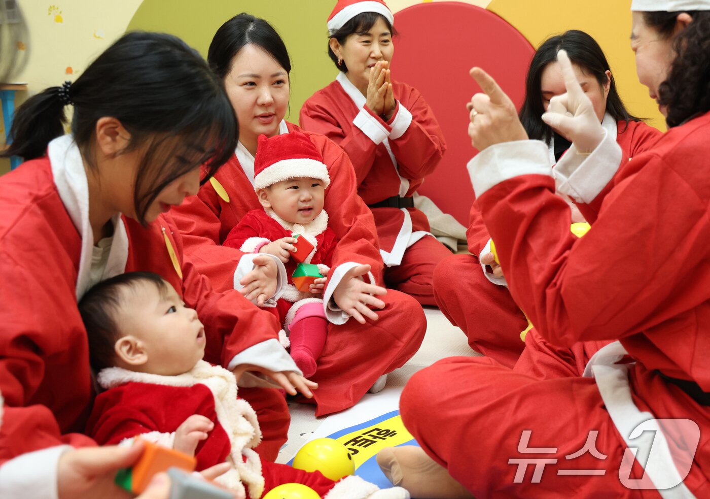 본문 이미지 - 크리스마스를 일주일 앞둔 18일 경기 광주시 능평도서관에서 산타 복장을 입은 엄마와 아기들이 놀이를 하고 있다. (공동취재) 2025.12.18/뉴스1 ⓒ News1 김영운 기자