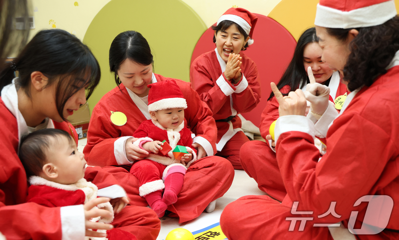(경기광주=뉴스1) 김영운 기자 = 크리스마스를 일주일 앞둔 18일 경기 광주시 능평도서관에서 산타 복장을 입은 엄마와 아기들이 놀이를 하고 있다. 2025.12.18/뉴스1