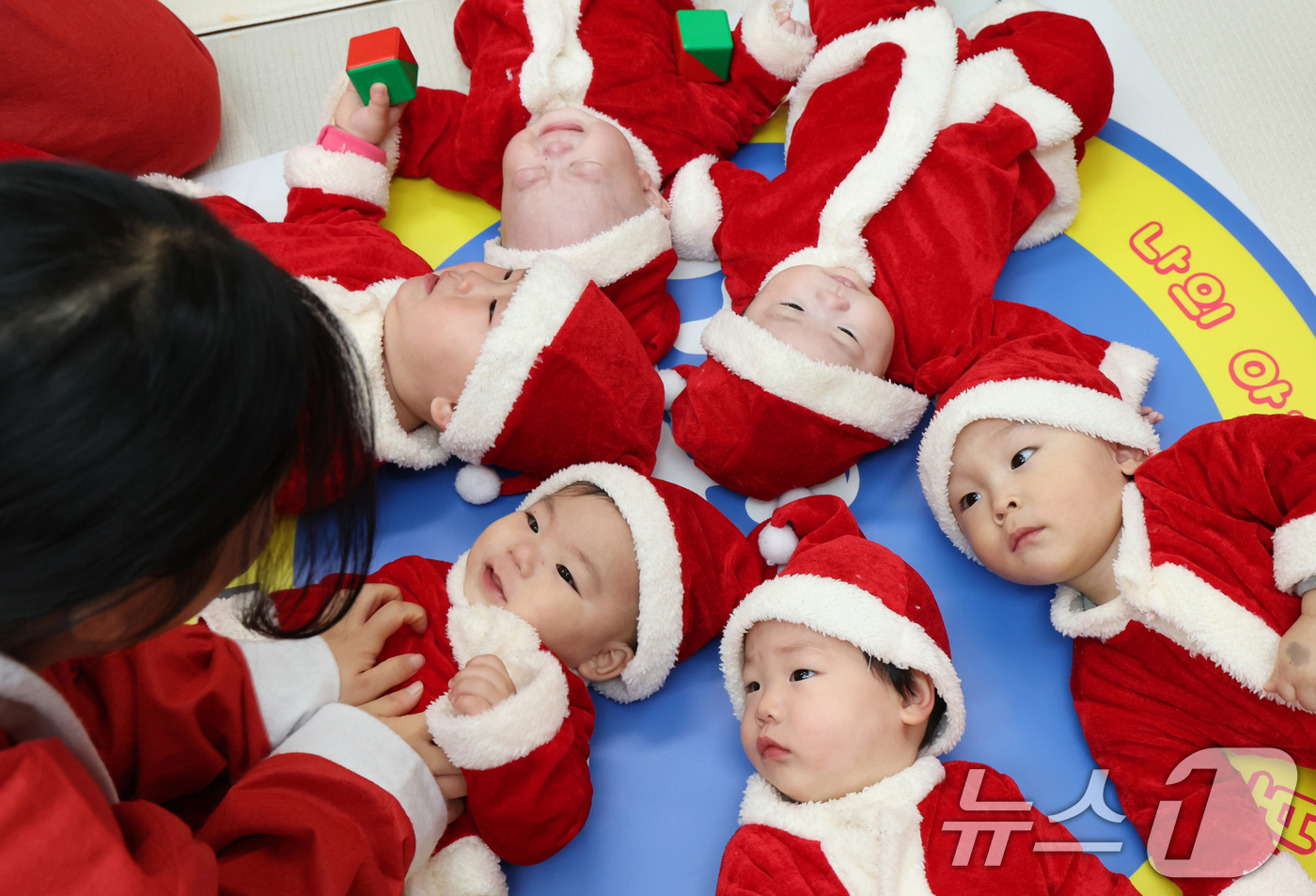 (경기광주=뉴스1) 김영운 기자 = 크리스마스를 일주일 앞둔 18일 경기 광주시 능평도서관에서 산타 복장을 입은 엄마와 아기들이 놀이를 하고 있다. 2025.12.18/뉴스1