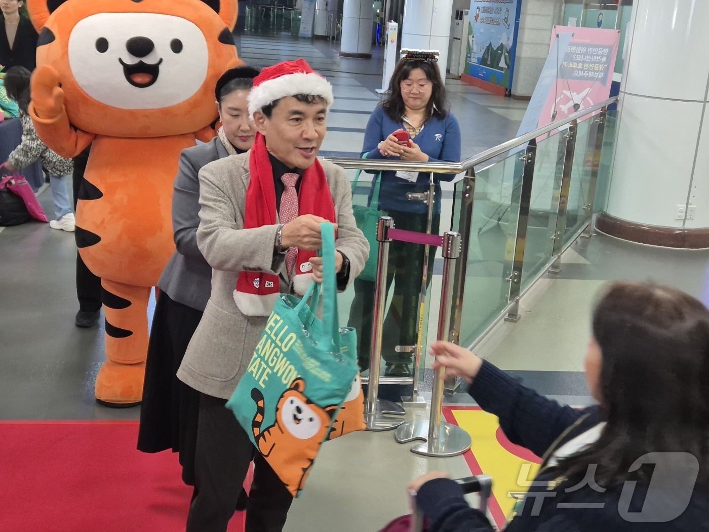 (양양=뉴스1) 윤왕근 기자 = 18일 강원 양양국제공항 입국장에서 김진태 강원도지사가 산타 복장을 한 채 필리핀 단체 관광객을 환영하고 있다.이날 필리핀 마닐라에서 도착한 관광객 …