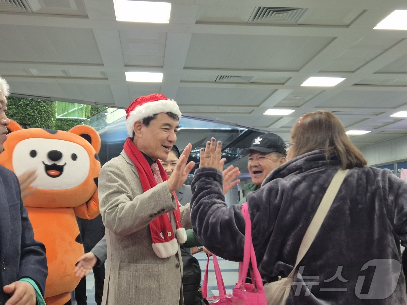 (양양=뉴스1) 윤왕근 기자 = 18일 강원 양양국제공항 입국장에서 김진태 강원도지사가 산타 복장을 한 채 필리핀 단체 관광객을 환영하고 있다.이날 필리핀 마닐라에서 도착한 관광객 …