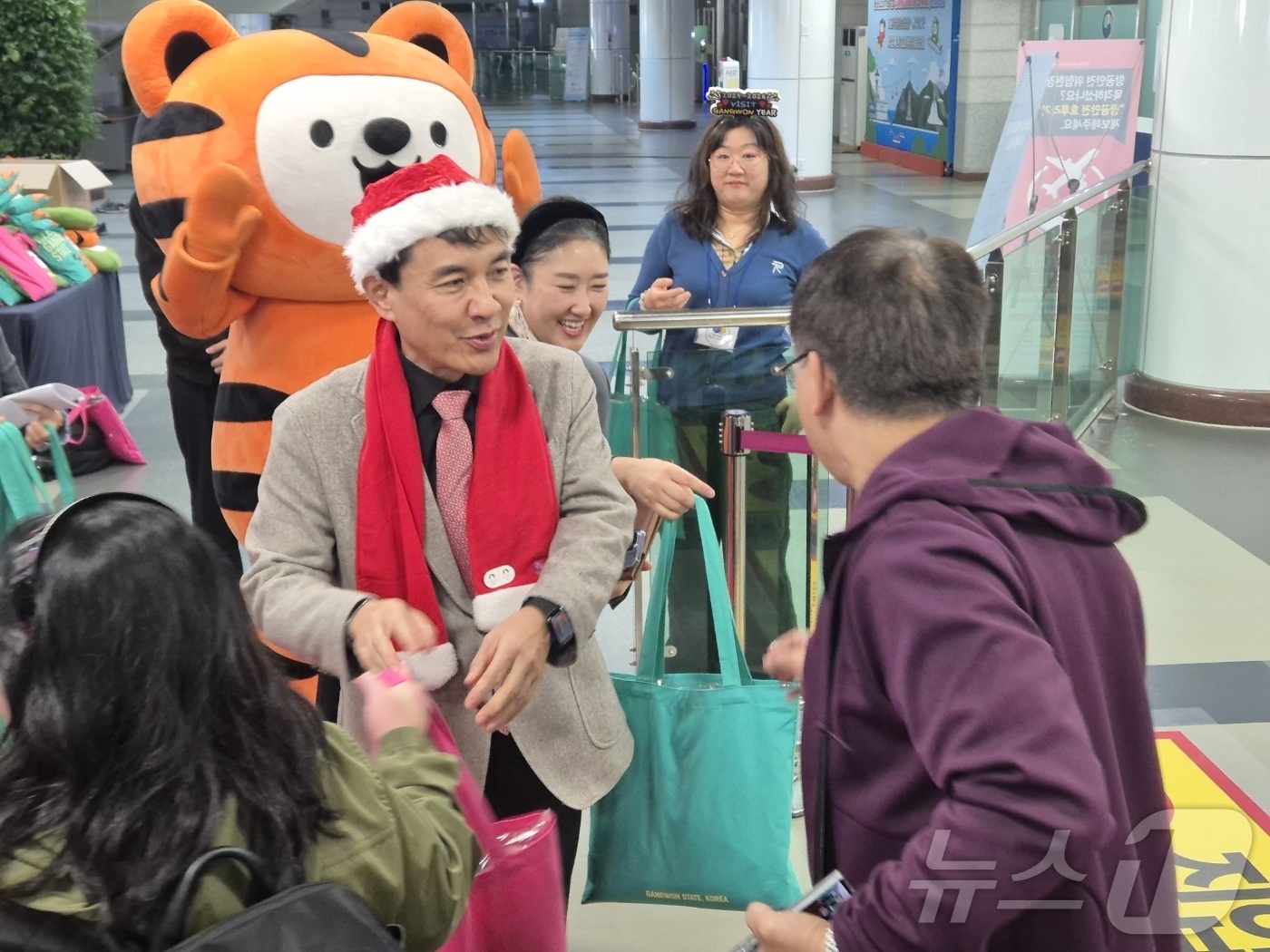 (양양=뉴스1) 윤왕근 기자 = 18일 강원 양양국제공항 입국장에서 김진태 강원도지사가 산타 복장을 한 채 필리핀 단체 관광객을 환영하고 있다.이날 필리핀 마닐라에서 도착한 관광객 …