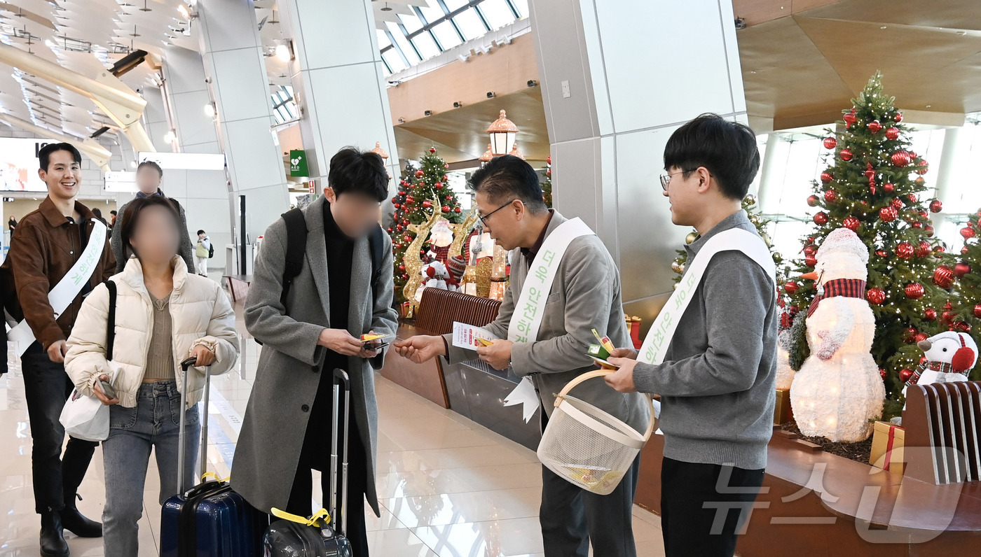 (서울=뉴스1) = 18일 서울 강서구 김포공항 국내선 터미널에서 열린 연말연시 항공보안 캠페인에서 김복근 한국공항공사 안전보안본부장이 김포공항 이용객에게 기내반입금지 물품 안내 …