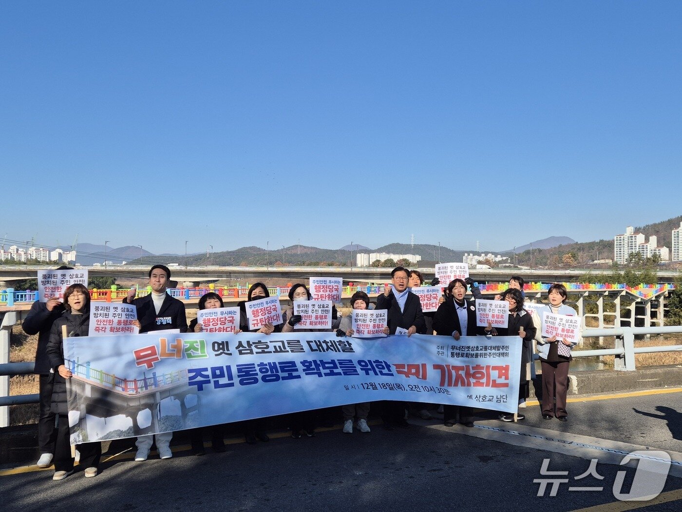 본문 이미지 - 안전한 통로 확보를 위한 주민대책위원회는 18일 삼호교 위에서 기자회견을 열고 주민 통행로 확보를 요구했다. 이들 뒤에 붕괴한 구 삼호교가 있다. 2025.12.18/뉴스1ⓒ 뉴스1 박정현기자