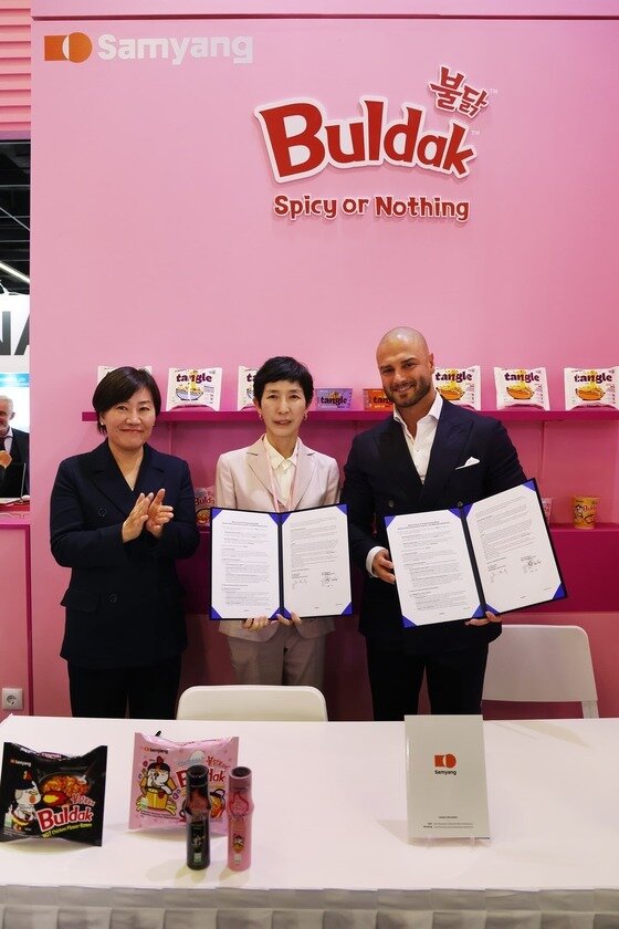 본문 이미지 - 지난 10월4일(현지시각) 독일 쾰른에서 열린 세계 최대 식품 박람회 '아누가(ANUGA) 2025' 삼양식품 부스에서 (왼쪽부터) 송미령 농림축산식품부 장관, 김정수 삼양식품 부회장, Melik Bektaş SRG International 최고상업책임자(CCO)가 기념 촬영을 하고 있다. (삼양식품 제공)