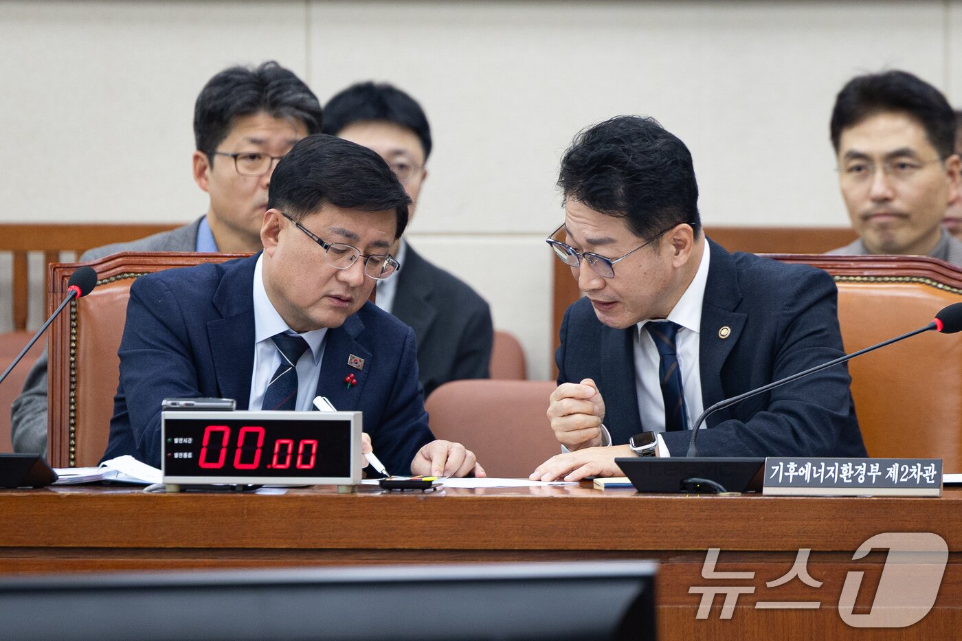 본문 이미지 - 김성환 기후에너지환경부 장관과 이호현 2차관이 서울 여의도 국회에서 열린 제430회 국회(임시회) 기후위기 특별위원회 제8차 전체회의에서 대화하고 있다. 2025.12.18/뉴스1 ⓒ News1 유승관 기자