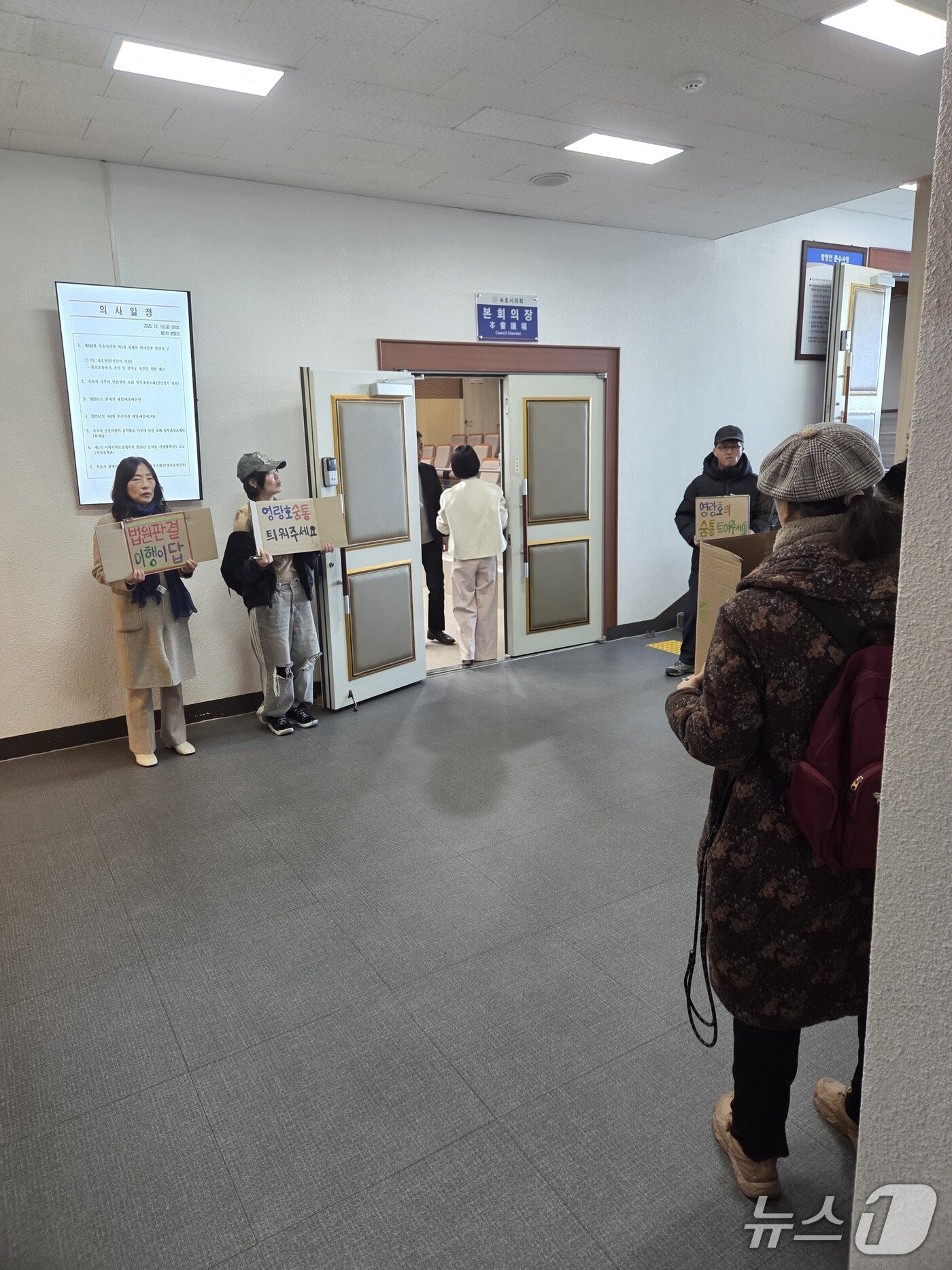 본문 이미지 - 속초시의회 예산결산특별위원회가 열린 19일 오전 속초지역 환경단체가 회의장 앞에서 영랑호 부교 철거 예산 통과를 촉구하며 피켓 시위를 벌이고 있다.(독자제공, 재판매 및 DB 금지) 2025.12.19/뉴스1