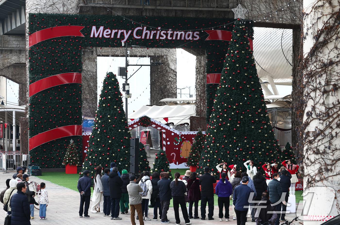 (서울=뉴스1) 김민지 기자 = 19일 오후 서울 뚝섬한강공원 자벌레 서울생각마루 인근에서 열린 2025 로맨틱 한강 크리스마스 마켓에서 시민들이 어린이 합창단 공연을 보고 있다. …