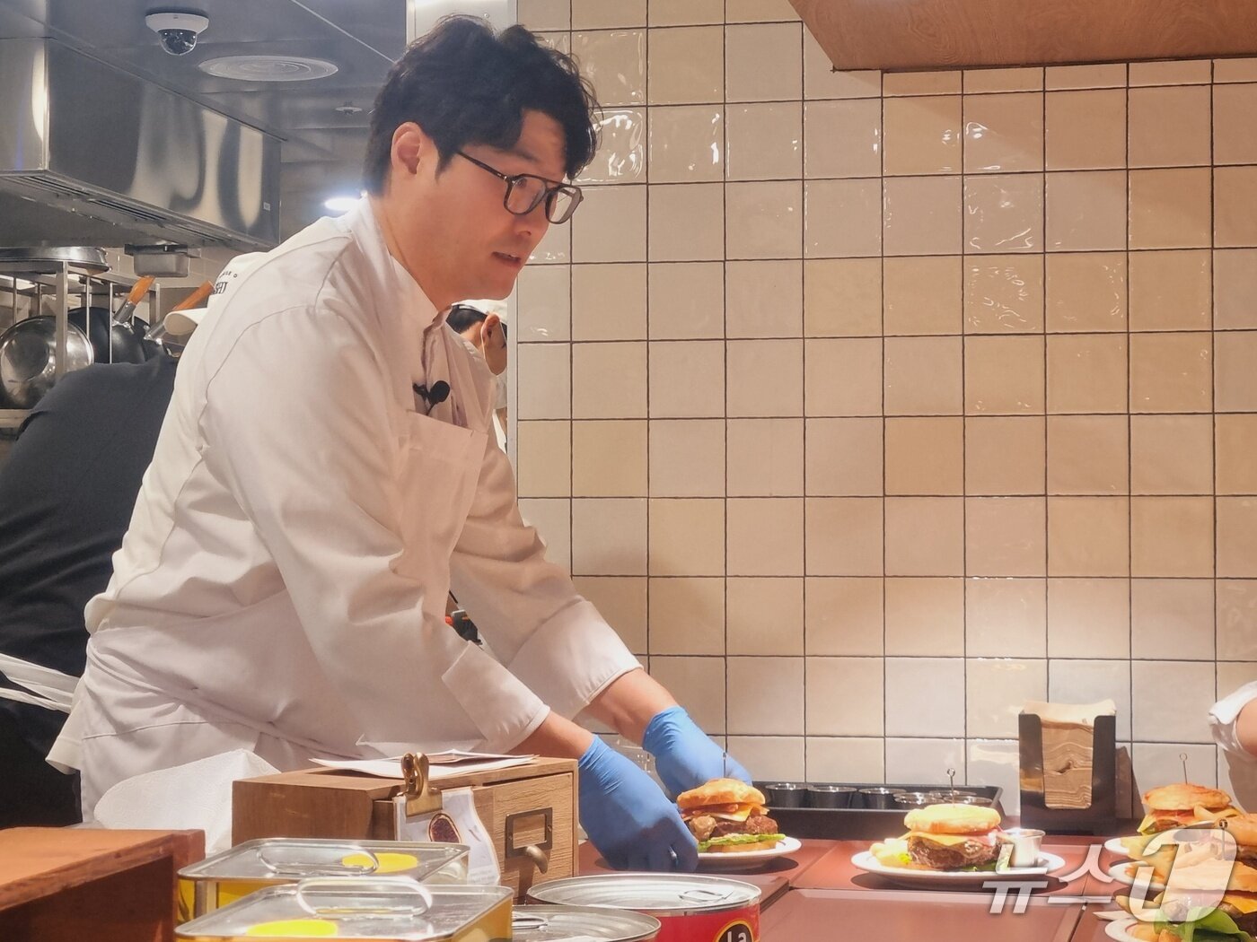 본문 이미지 - 오세득 셰프가 19일 오후 '하우스오브애슐리' 팝업 프리오픈 행사에서 직접 만든 '비프 웰링턴 버거'를 선보이고 있다. 2025.12.19/뉴스1 박혜연 기자 ⓒ 뉴스1