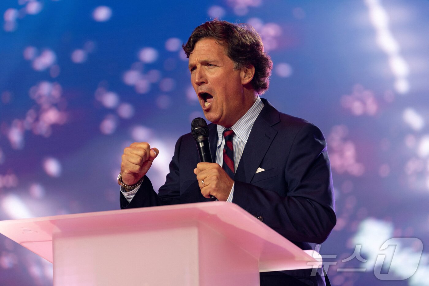 본문 이미지 - 폭스뉴스 출신 보수 논객 터커 칼슨이 18일(현지시간) 미국 애리조나주 피닉스에서 열린 미국 청년 보수 단체인 터닝포인트 USA의 연례 행사 '아메리카페스트'에서 연설하고 있다. 2025.12.18. ⓒ 로이터=뉴스1 ⓒ News1 이정환 기자