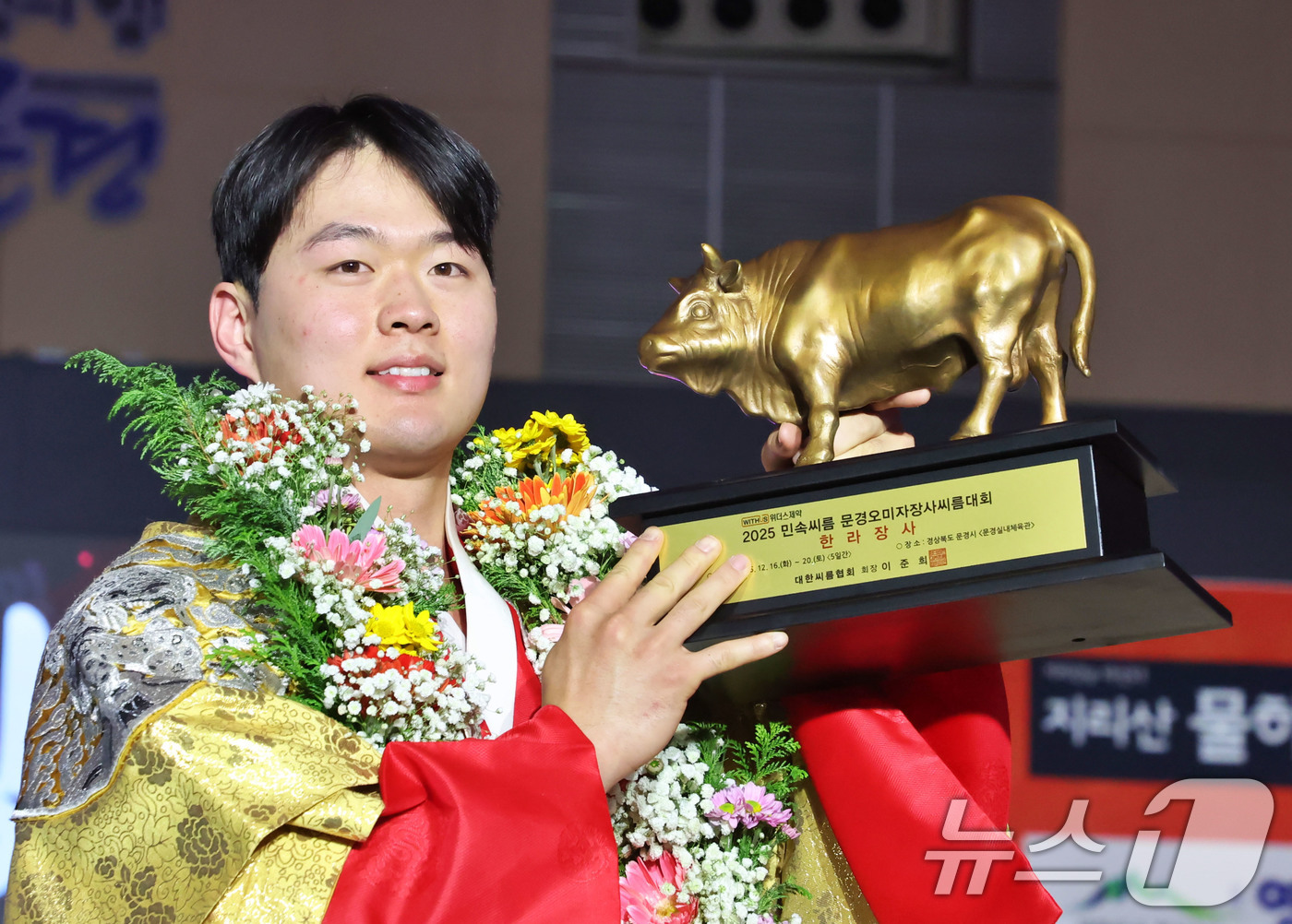 (서울=뉴스1) = 19일 경상북도 문경시 문경실내체육관에서 열린 ‘위더스제약 2025 의성천하장사씨름대축제’ 한라장사(105kg이하)에 등극한 박민교(용인특례시청)가 황소트로피를 …