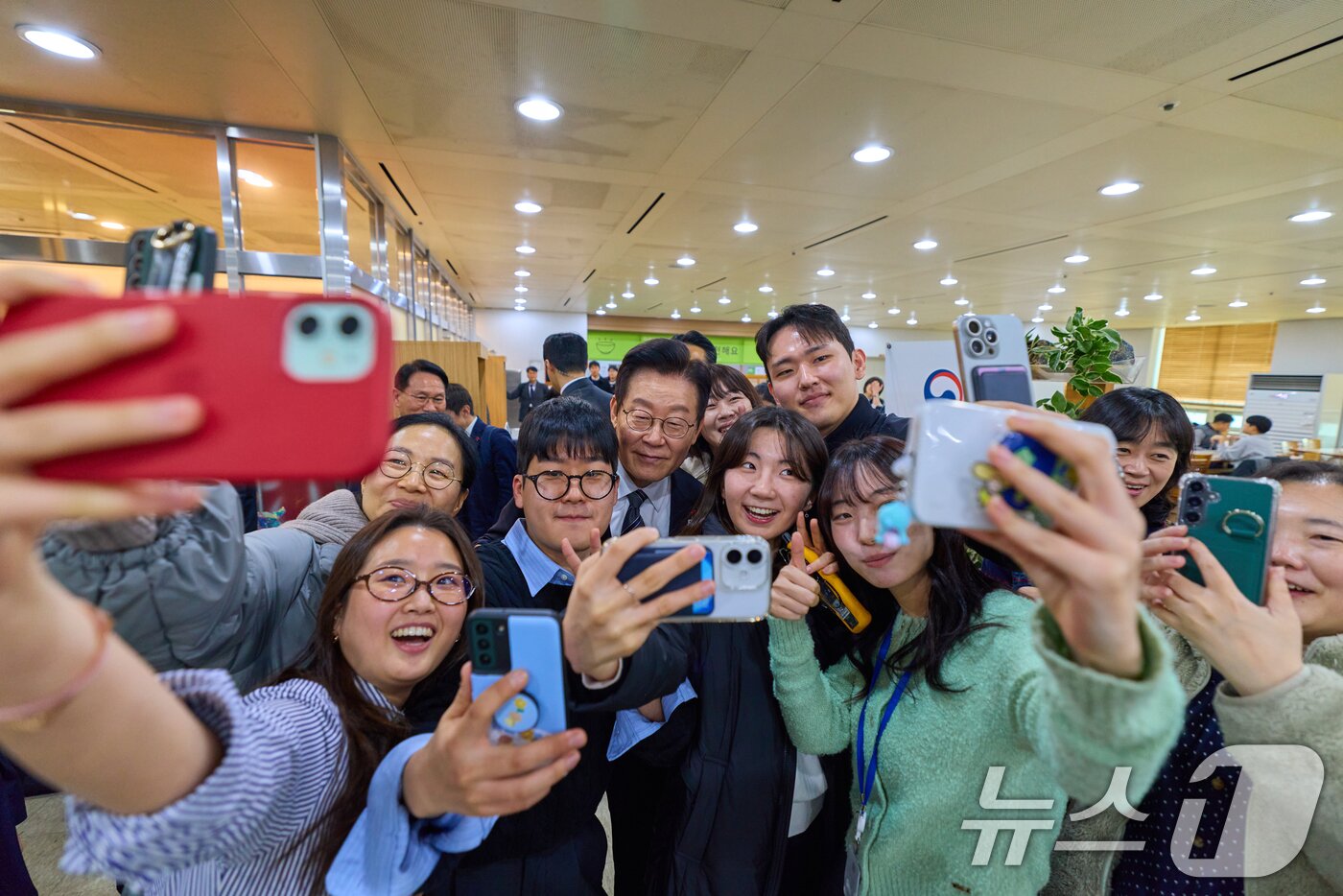 본문 이미지 - 이재명 대통령이 정부 업무보고를 마친 뒤 서울 종로구 정부서울청사 별관 구내식당을 찾아 직원들과 기념촬영을 하고 있다. (대통령실 제공. 재판매 및 DB 금지) 2025.12.19/뉴스1 ⓒ News1 허경 기자