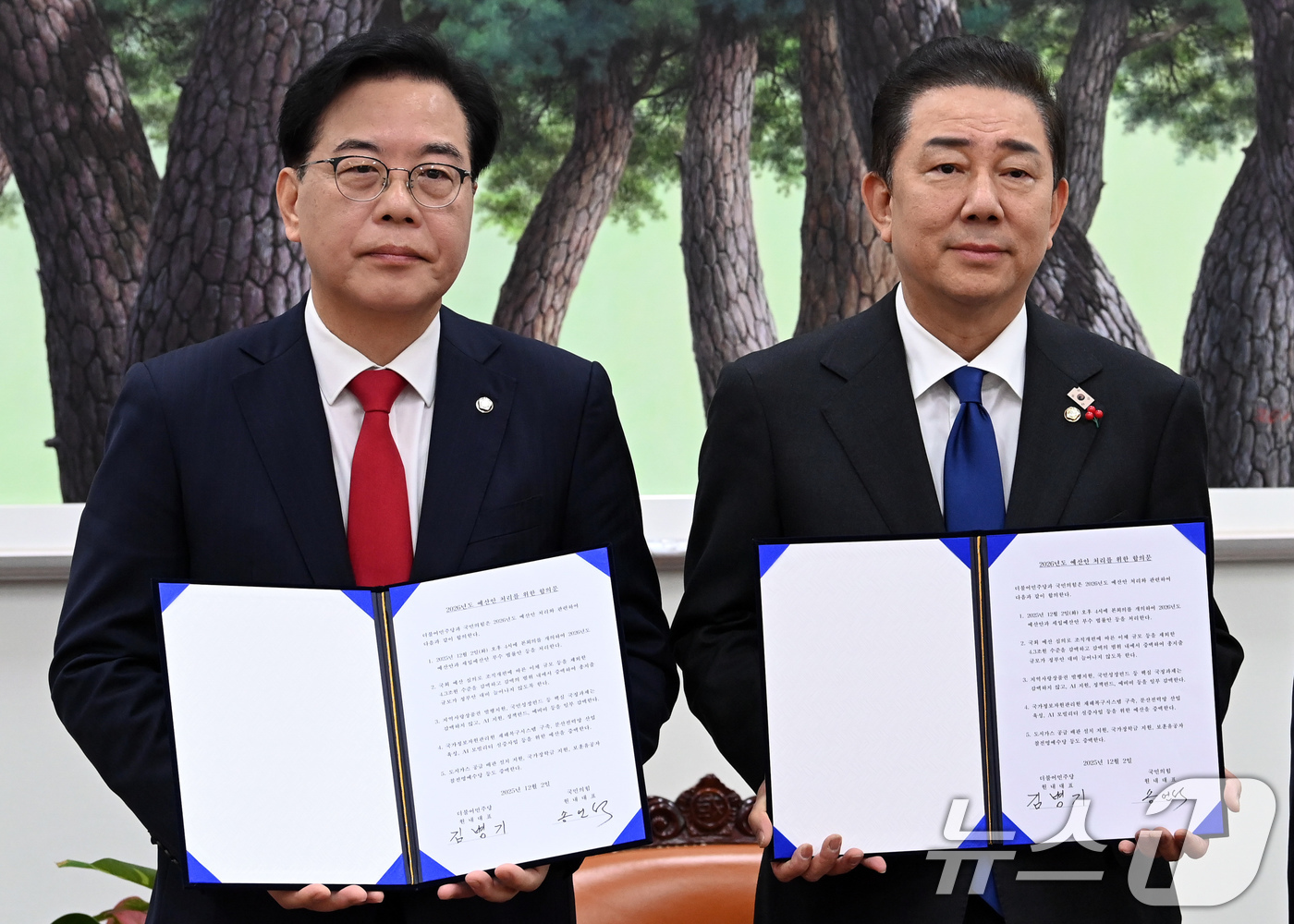 (서울=뉴스1) 유승관 기자 = 송언석 국민의힘 원내대표(왼쪽), 김병기 더불어민주당 원내대표가 2일 서울 여의도 국회에서 2026년도 예산안 처리를 위한 합의문에 서명을 마치고 …