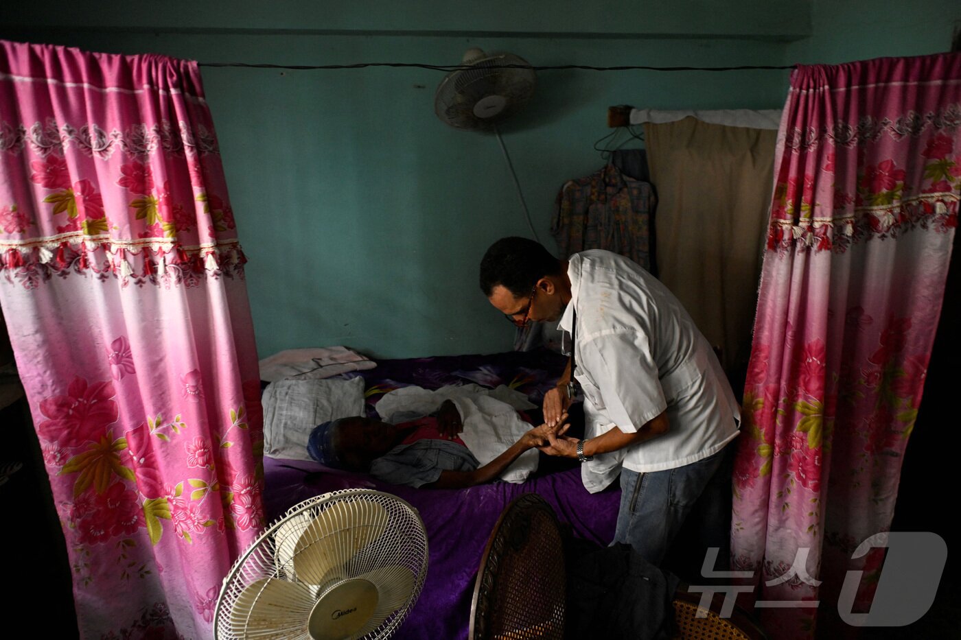 본문 이미지 - 지난달 18일&#40;현지시간&#41; 쿠바 의사 후스토 베니테스가 모기 매개 질병이 만연한 쿠바 아바나에서 루이사 수아레스의 집을 진찰하고 있다. 2025.11.18. ⓒ 로이터=뉴스1 ⓒ News1 이정환 기자