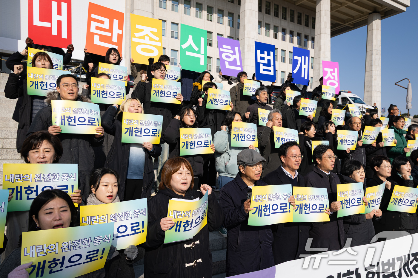 (서울=뉴스1) 유승관 기자 = 2일 서울 여의도 국회 본청 앞 계단에서 열린 내란종식을 위한 헌법개정 촉구 시국 기자회견에서 참석자들이 구호를 외치고 있다. 2025.12.2/뉴 …