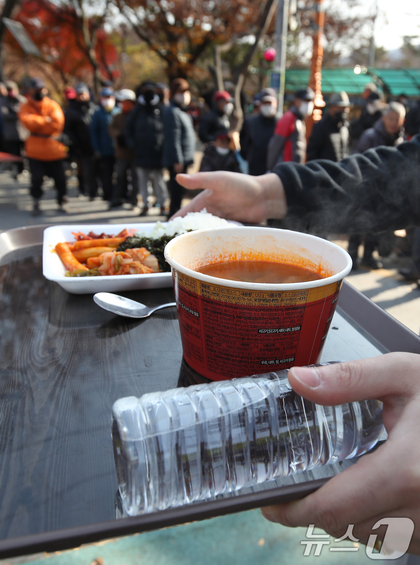(대구=뉴스1) 공정식 기자 = 초겨울 추위가 찾아온 2일 오전 대구 달서구 두류공원 사랑해밥차 무료급식소에서 점심 배식 식판을 받은 사람들이 식사할 곳으로 이동하고 있다. 202 …