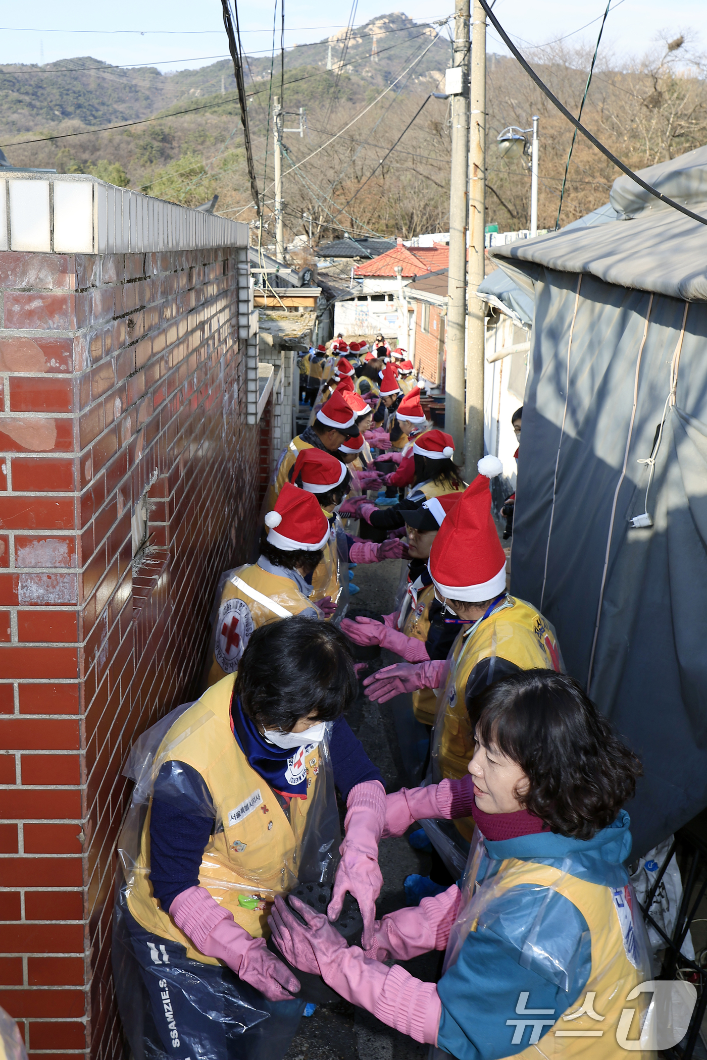 (서울=뉴스1) 박정호 기자 = 고려아연 임직원들과 대한적십자사 봉사원들이 2일 오후 서울 노원구 상계동 일대에서 취약계층에게 전달할 연탄을 나르고 있다.이날 진행된 사랑의 연탄 …