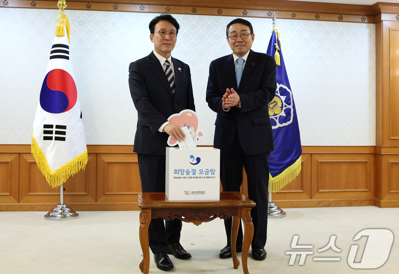 (서울=뉴스1) 임세영 기자 = 김민석 국무총리(왼쪽)가 2일 서울 종로구 정부서울청사에서 열린 크리스마스 씰 증정식에서 모금함에 성금을 넣고 있다. 2025.12.2/뉴스1