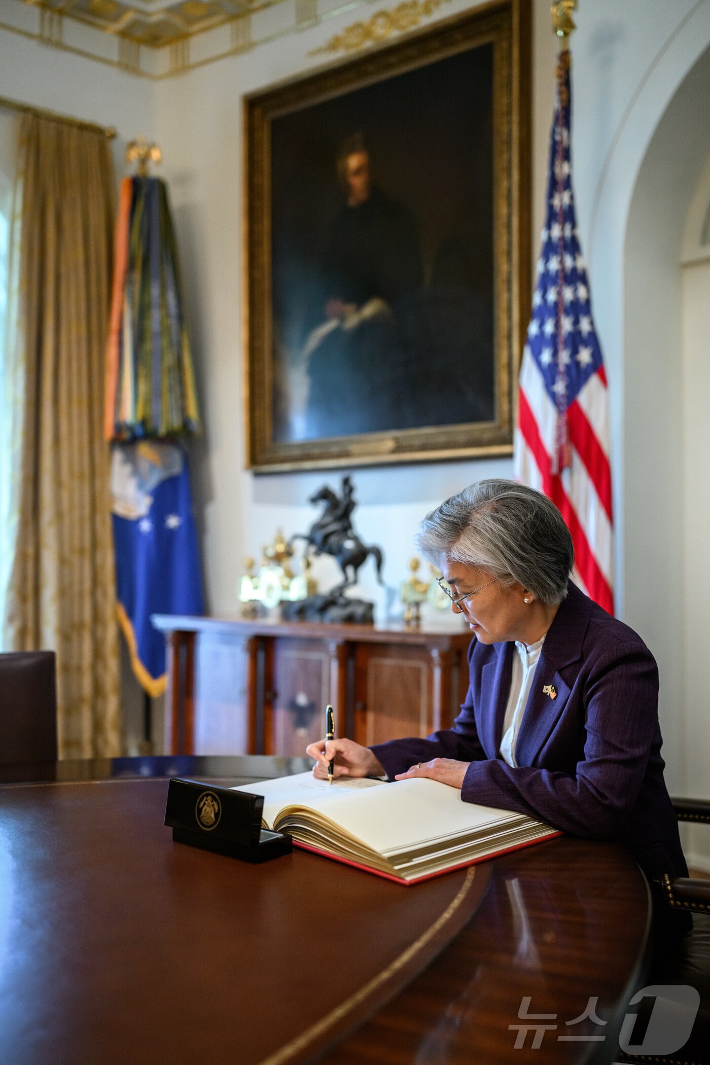 본문 이미지 - 강경화 주미대사가 지난 16일(현지시간) 미국 워싱턴DC 백악관에서 열린 임명장 제정 기념 촬영행사에서 방명록에 서명하고 있다.(주미대사관 제공, 재판매 및 DB금지) 2025.12.19. ⓒ News1 류정민 특파원