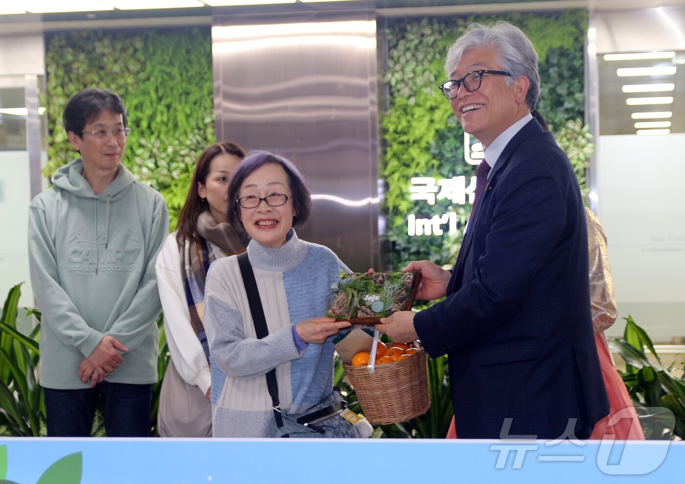 본문 이미지 - 20일 오후 제주국제공항 국제선 입국장에서 일본 후쿠오카발 직항기(티웨이항공 TW228편)를 타고 제주를 찾은 일본 관광객들이 도착해 환영 선물을 받고 있다. 제주~후쿠오카 직항 노선은 코로나19 팬데믹으로 2020년 이후 중단됐다가 6년 만에 재개됐다.2025.12.20/뉴스1 ⓒ News1 홍수영 기자