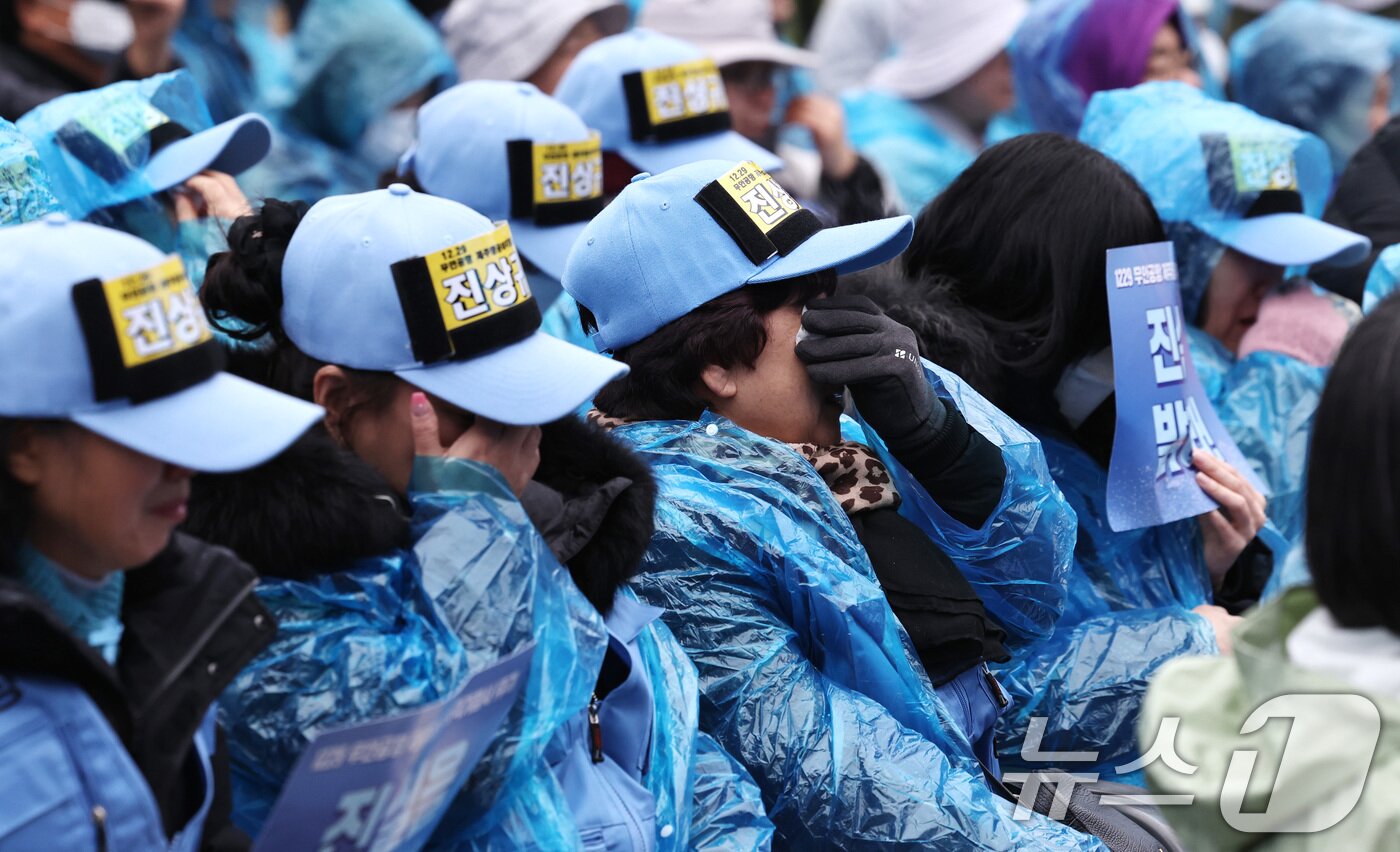 본문 이미지 - 20일 오후 서울 종로구 보신각 앞에서 열린 '12·29 무안공항 제주항공 여객기 참사 1주기 전국 시민 추모대회'에서 여객기 참사 유가족들이 눈물을 닦고 있다. 2025.12.20/뉴스1 ⓒ News1 구윤성 기자