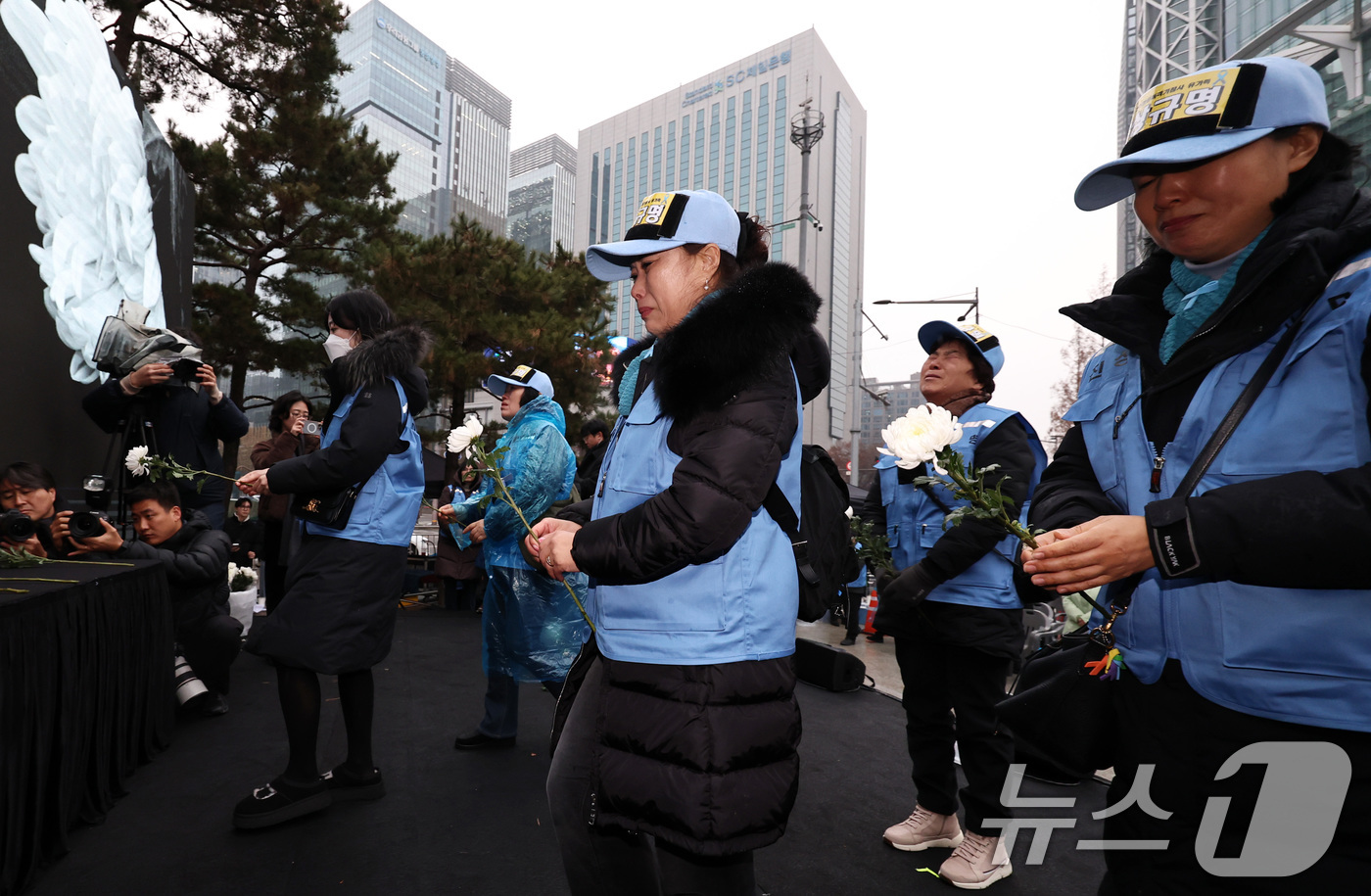 (서울=뉴스1) 구윤성 기자 = 20일 오후 서울 종로구 보신각 앞에서 열린 '12·29 무안공항 제주항공 여객기 참사 1주기 전국 시민 추모대회'에서 여객기 참사 유가족들이 헌화 …
