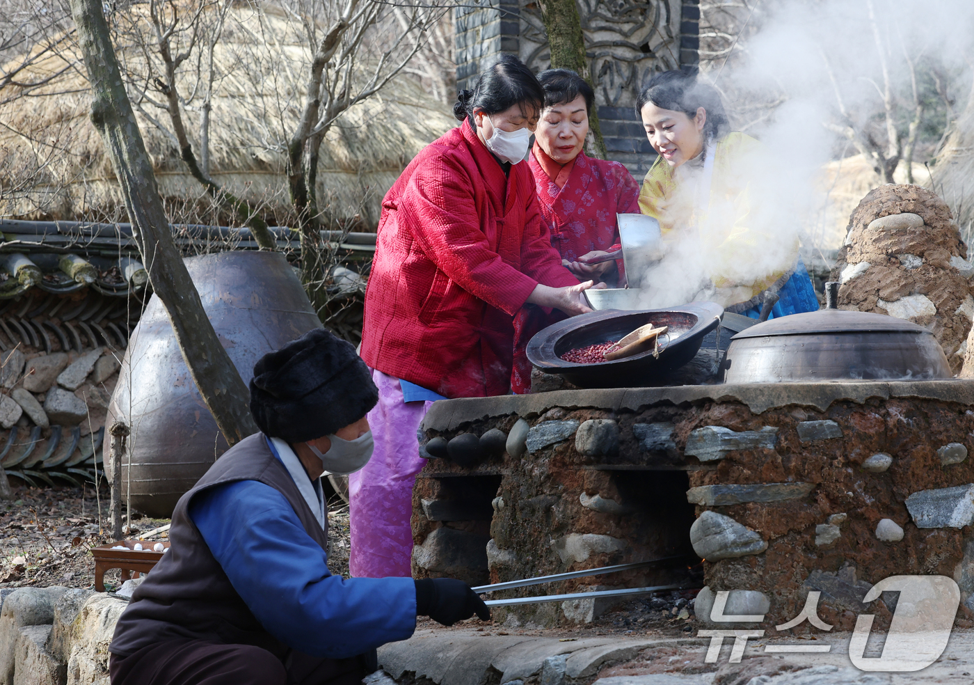 (용인=뉴스1) 김영운 기자 = 절기상 동지(冬至)를 하루 앞둔 21일 경기 용인시 기흥구 한국민속촌에서 직원들이 팥죽을 쑤고 있다. 2025.12.21/뉴스1