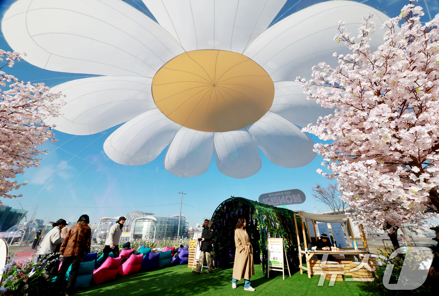 (서울=뉴스1) 이호윤 기자 = 21일 서울 서초구 반포한강공원에서 열린 2025 한강페스티벌 '봄ON한강'을 찾은 시민들이 봄꽃 에어돔을 둘러보고 있다. 2025.12.21/뉴스 …