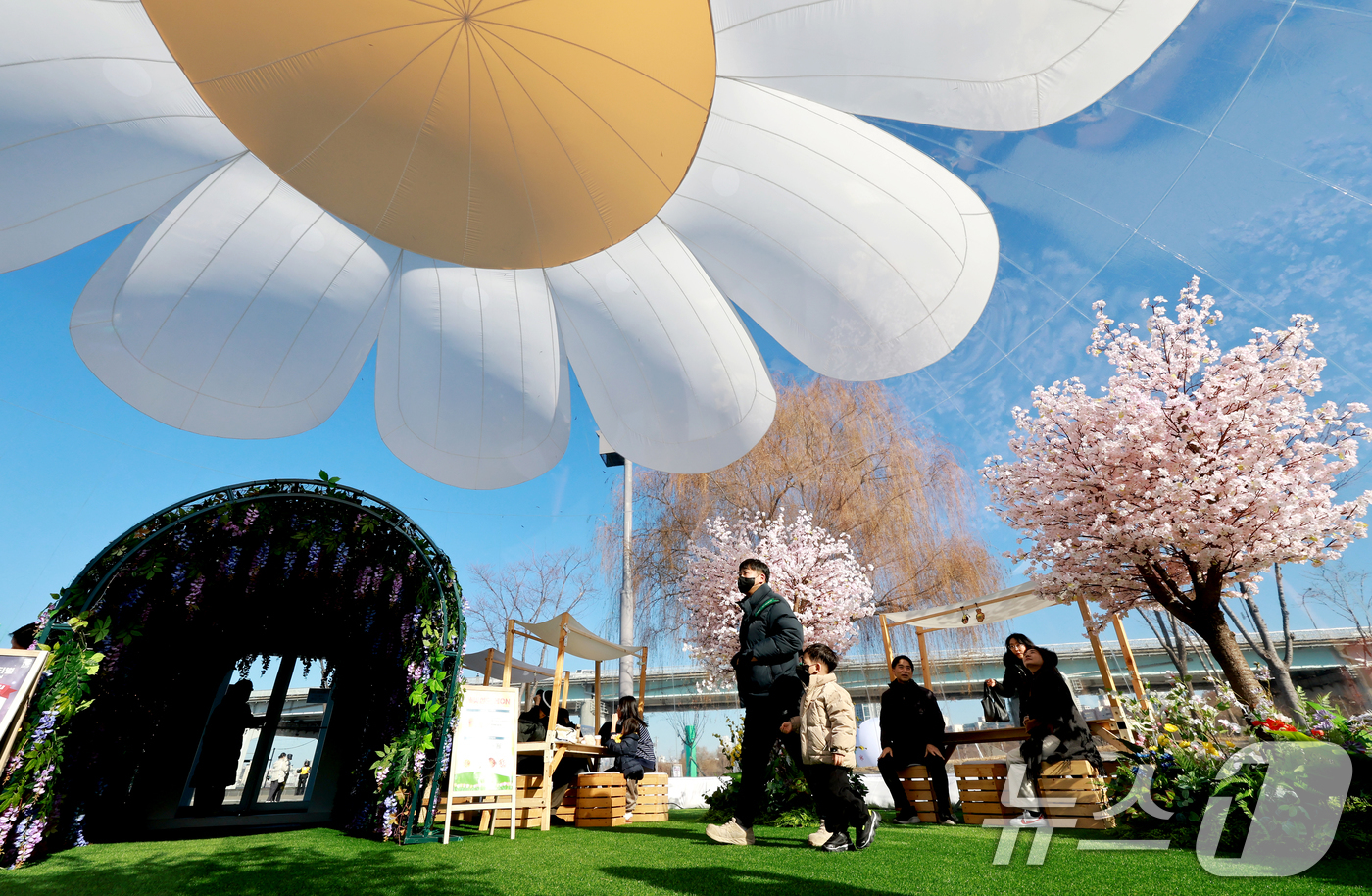 (서울=뉴스1) 이호윤 기자 = 21일 서울 서초구 반포한강공원에서 열린 2025 한강페스티벌 '봄ON한강'을 찾은 시민들이 봄꽃 에어돔을 둘러보고 있다. 2025.12.21/뉴스 …