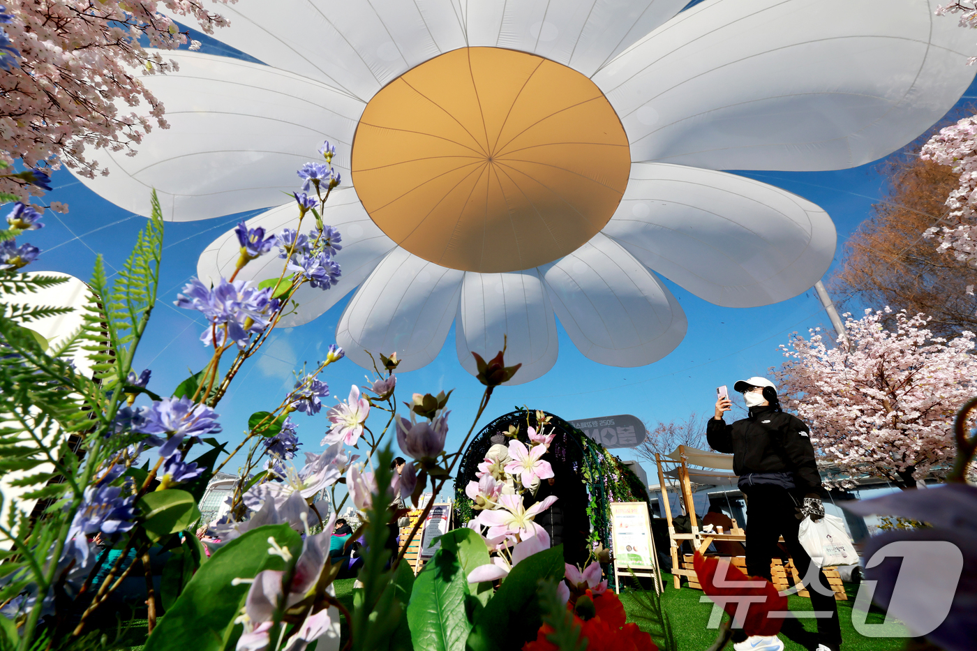 (서울=뉴스1) 이호윤 기자 = 21일 서울 서초구 반포한강공원에서 열린 2025 한강페스티벌 '봄ON한강'을 찾은 시민들이 봄꽃 에어돔을 둘러보고 있다. 2025.12.21/뉴스 …
