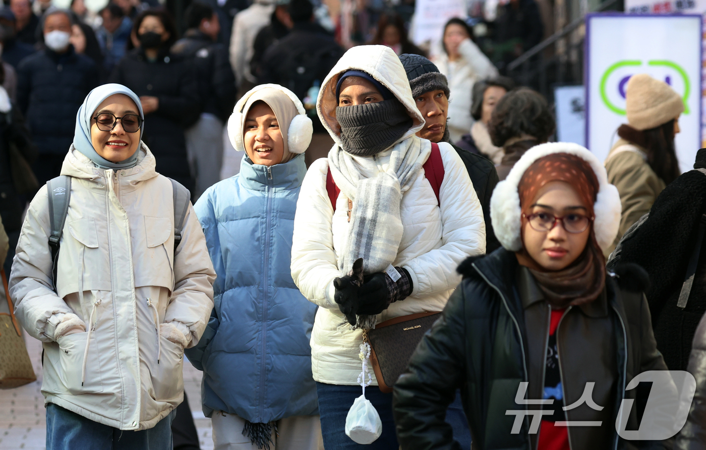 (서울=뉴스1) 김명섭 기자 = 휴일인 21일 서울 명동에서 외국인 관광객들이 추운 날씨속에서 연말을 보내고 있다. 이날 서울 낮기온은 2도를 보였다. 한편 연중 밤의 길이가 가장 …