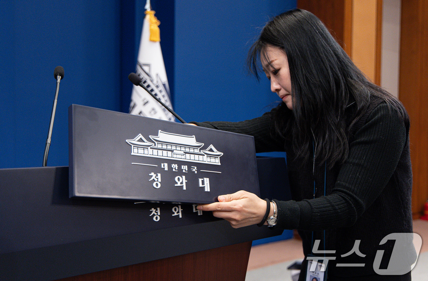 (서울=뉴스1) 이재명 기자 = 대통령실이 청와대 순차 이전을 진행 중인 21일 청와대 춘추관 브리핑룸에서 직원이 탈부착 업무표장을 설치하고 있다. 2025.12.21/뉴스1