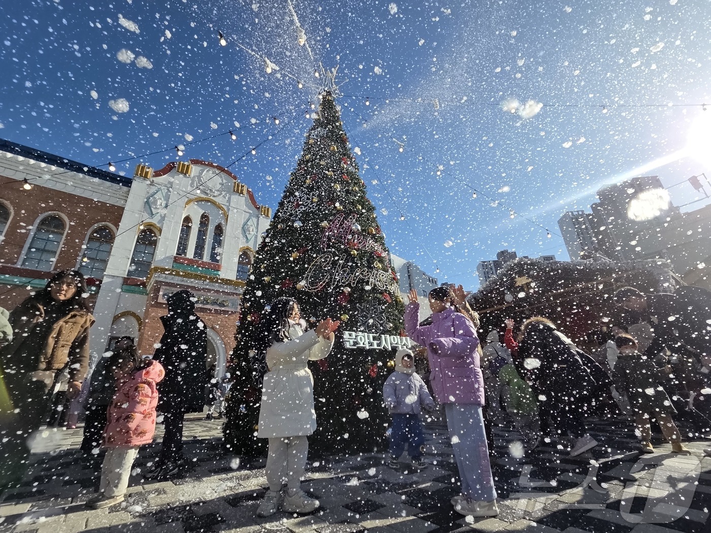 (익산=뉴스1) 문채연 기자 = 21일 오후 전북 익산시 중앙동 익산근대역사관 광장에서 진행된 '인공 눈 퍼포먼스'를 시민들이 즐기고 있다.2025.12.21/뉴스1