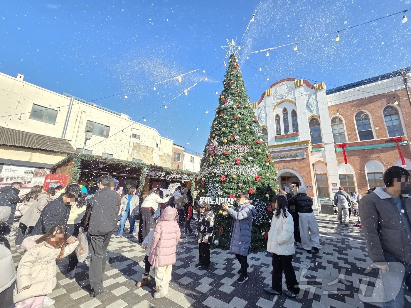 본문 이미지 - 21일 오후 2시께 전북 익산시 중앙동 익산근대역사관 광장에서 진행된  '인공 눈 퍼포먼스'를 시민들이 즐기고 있다.2025.12.21/뉴스1 문채연 기자 ⓒ News1 문채연 기자