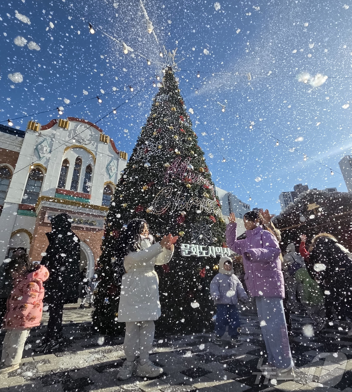 (익산=뉴스1) 문채연 기자 = 21일 오후 전북 익산시 중앙동 익산근대역사관 광장에서 진행된 '인공 눈 퍼포먼스'를 시민들이 즐기고 있다. 2025.12.21/뉴스1