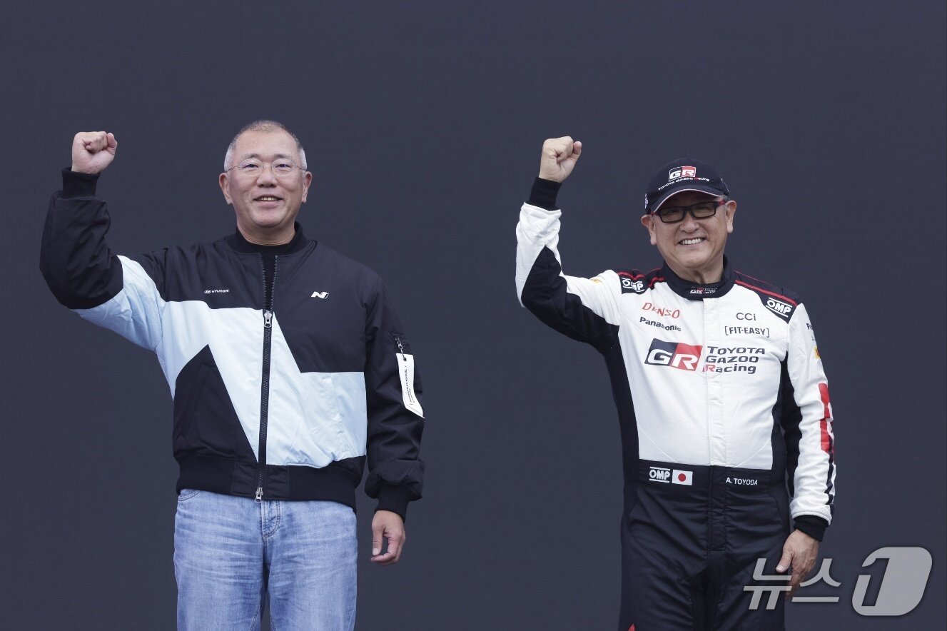 본문 이미지 - 지난해 10월 용인 에버랜드 스피드웨이에서 현대자동차그룹과 도요타그룹이 공동으로 개최한 '현대 N x 토요타 가주 레이싱' 페스티벌에서 정의선 현대차그룹 회장(왼쪽)과 토요다 아키오 도요타그룹 회장(오른쪽)이 스테이지에 올라 관중들 앞에서 주먹을 불끈 쥐어 보이는 모습(현대차그룹 제공). 2025.10.27.