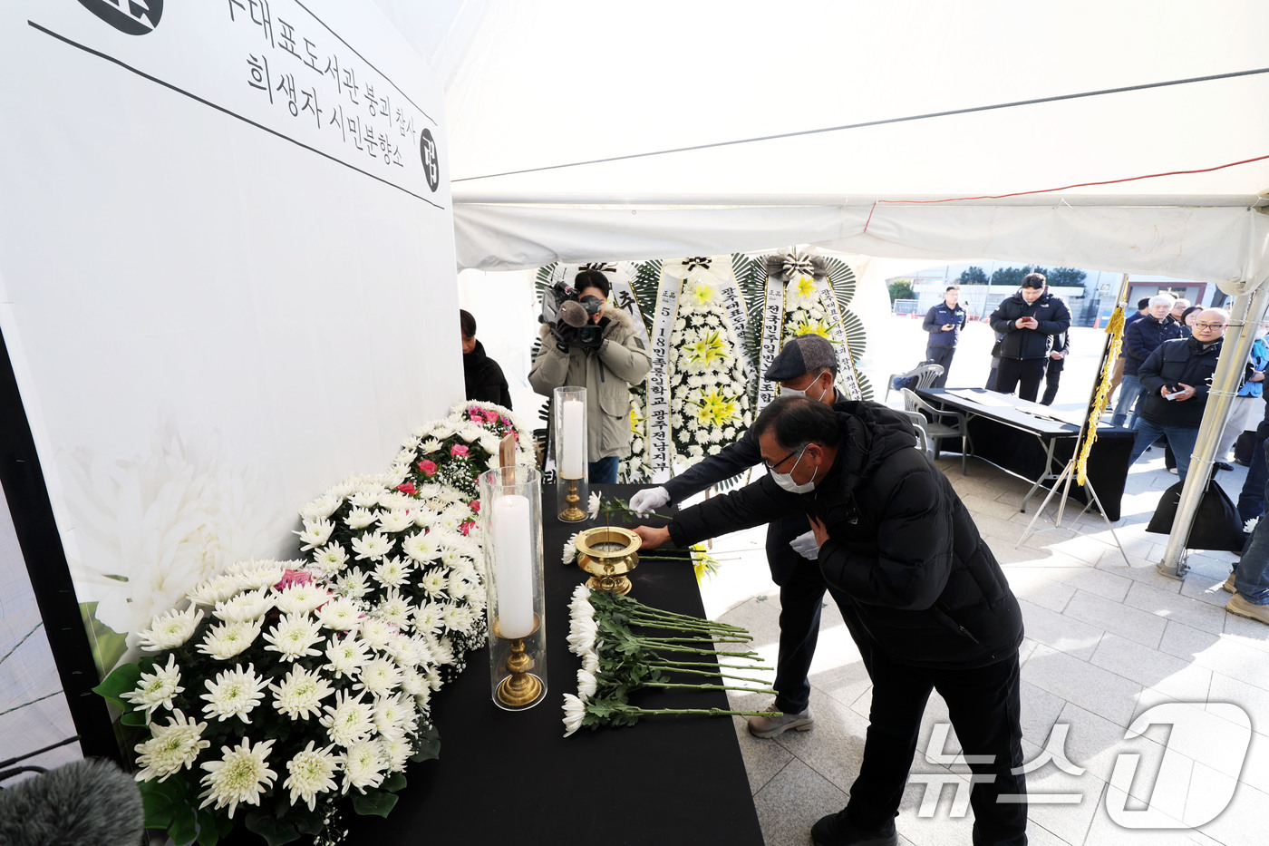 (광주=뉴스1) 이승현 기자 = 광주대표도서관 붕괴사고 유가족들이 22일 오전 광주 동구 5·18민주광장에 마련된 '광주대표도서관 붕괴 참사 희생자 시민 분향소'에서 헌화하고 있다 …