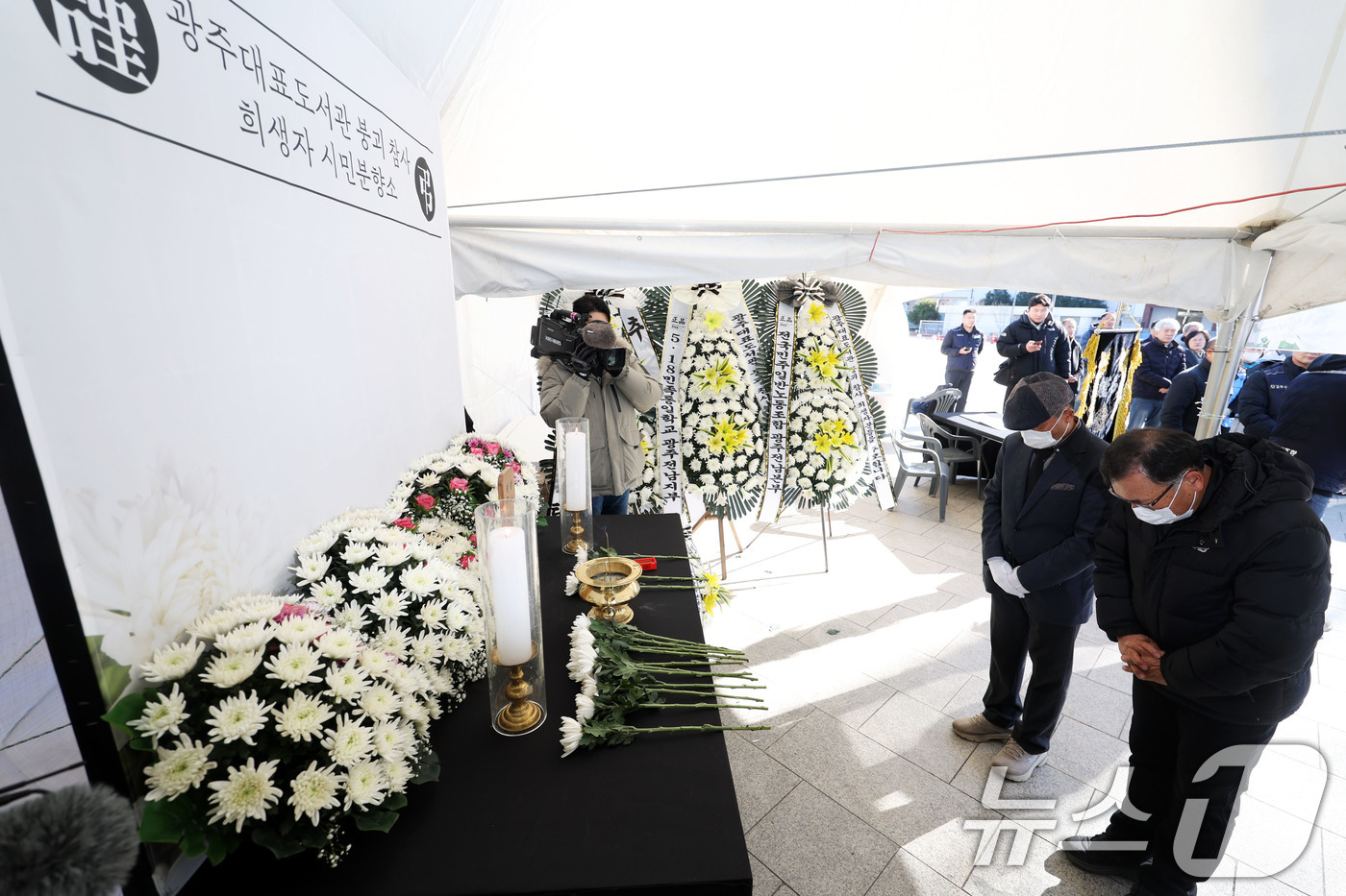 (광주=뉴스1) 이승현 기자 = 광주대표도서관 붕괴사고 유가족들이 22일 오전 광주 동구 5·18민주광장에 마련된 '광주대표도서관 붕괴 참사 희생자 시민 분향소'에서 묵념하고 있다 …