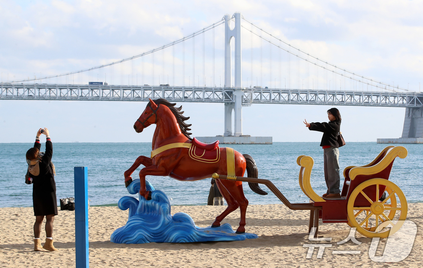 (부산=뉴스1) 윤일지 기자 = 22일 오후 부산 수영구 광안리해수욕장을 찾은 관광객들이 2026년 병오년(丙午年) 붉은 말의 해를 맞아 설치된 새해 말 조형물에서 기념사진을 찍고 …