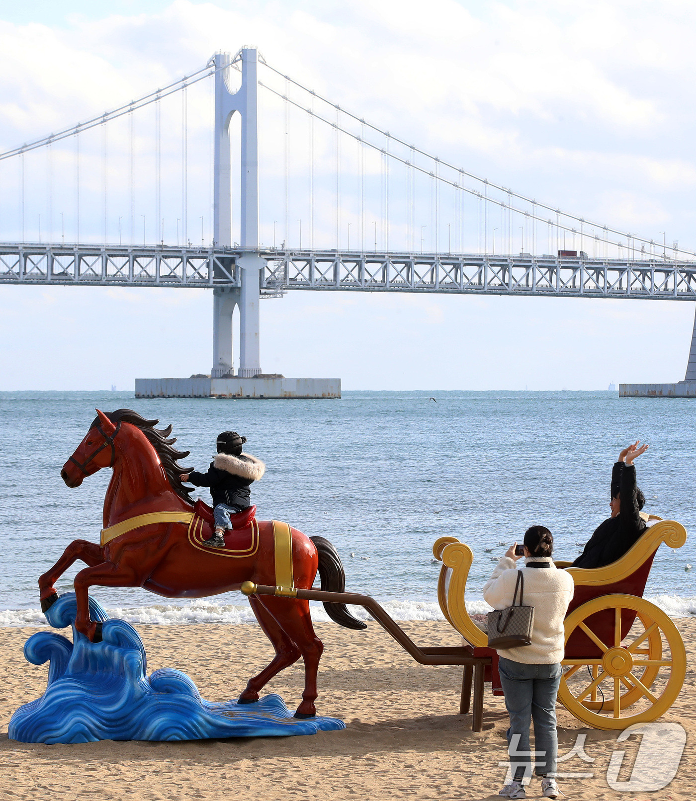 (부산=뉴스1) 윤일지 기자 = 22일 오후 부산 수영구 광안리해수욕장을 찾은 한 가족이 2026년 병오년(丙午年) 붉은 말의 해를 맞아 설치된 새해 말 조형물에서 기념사진을 찍고 …