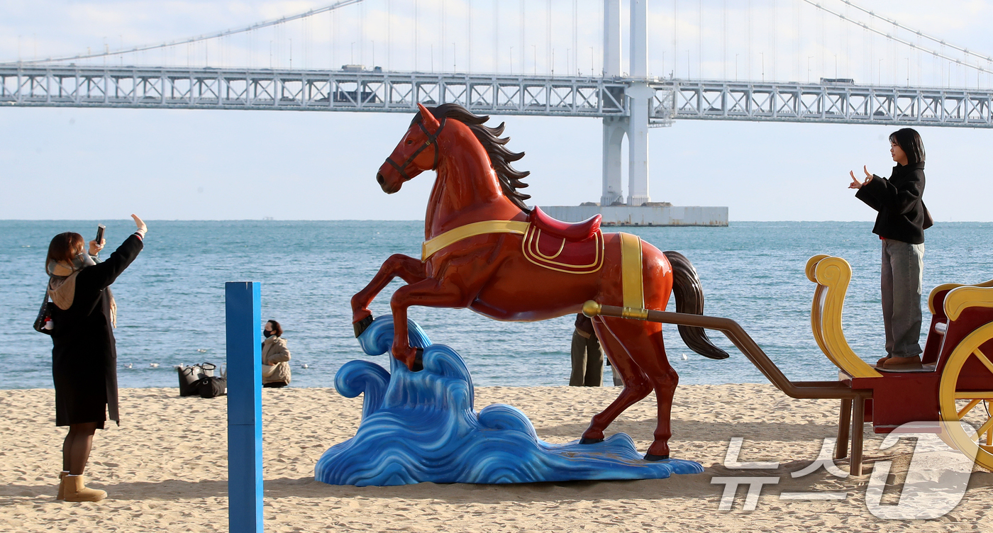 (부산=뉴스1) 윤일지 기자 = 22일 오후 부산 수영구 광안리해수욕장을 찾은 관광객들이 2026년 병오년(丙午年) 붉은 말의 해를 맞아 설치된 새해 말 조형물에서 기념사진을 찍고 …