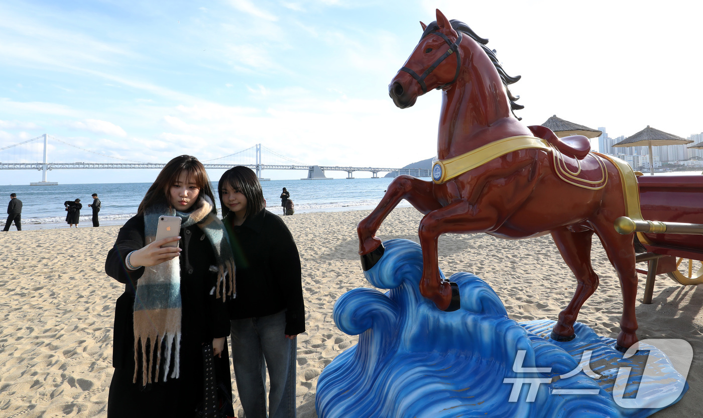 (부산=뉴스1) 윤일지 기자 = 22일 오후 부산 수영구 광안리해수욕장을 찾은 관광객들이 2026년 병오년(丙午年) 붉은 말의 해를 맞아 설치된 새해 말 조형물에서 기념사진을 찍고 …