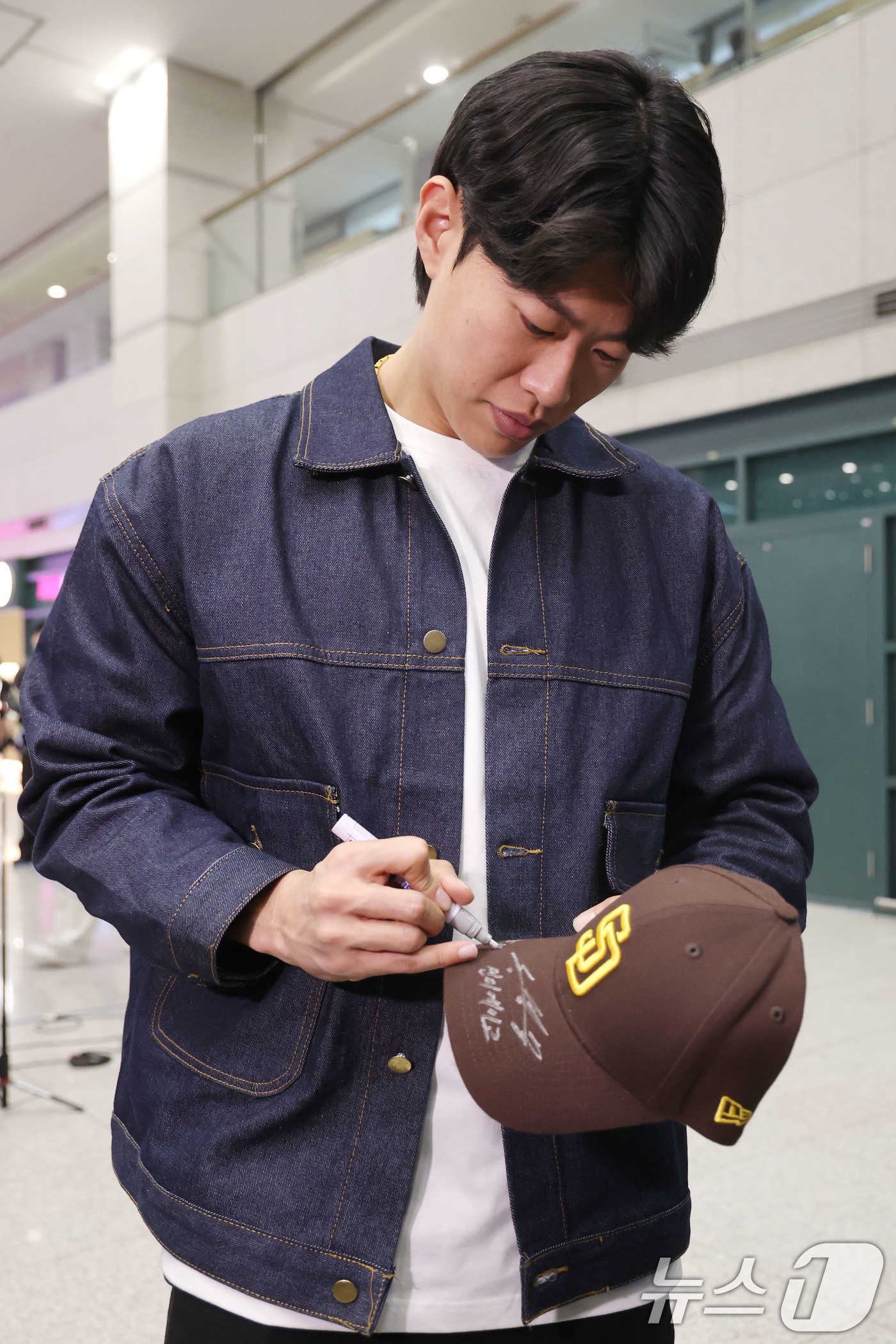 (인천공항=뉴스1) 이광호 기자 = 미국프로야구 메이저리그(MLB) 샌디에이고 파드리스와 4년 계약을 맺은 송성문이 23일 오전 인천국제공항을 통해 귀국해 한 팬에게 사인을 해주고 …