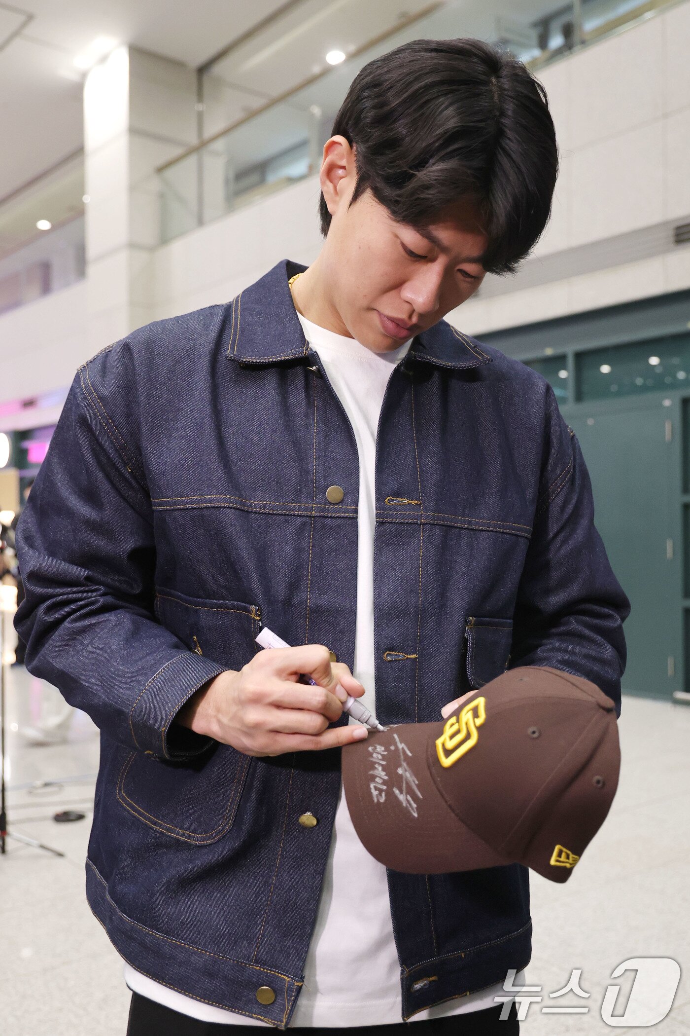 본문 이미지 - 미국프로야구 메이저리그(MLB) 샌디에이고 파드리스와 4년 계약을 맺은 송성문이 23일 오전 인천국제공항을 통해 귀국해 한 팬에게 사인을 해주고 있다. 2025.12.23/뉴스1 ⓒ News1 이광호 기자