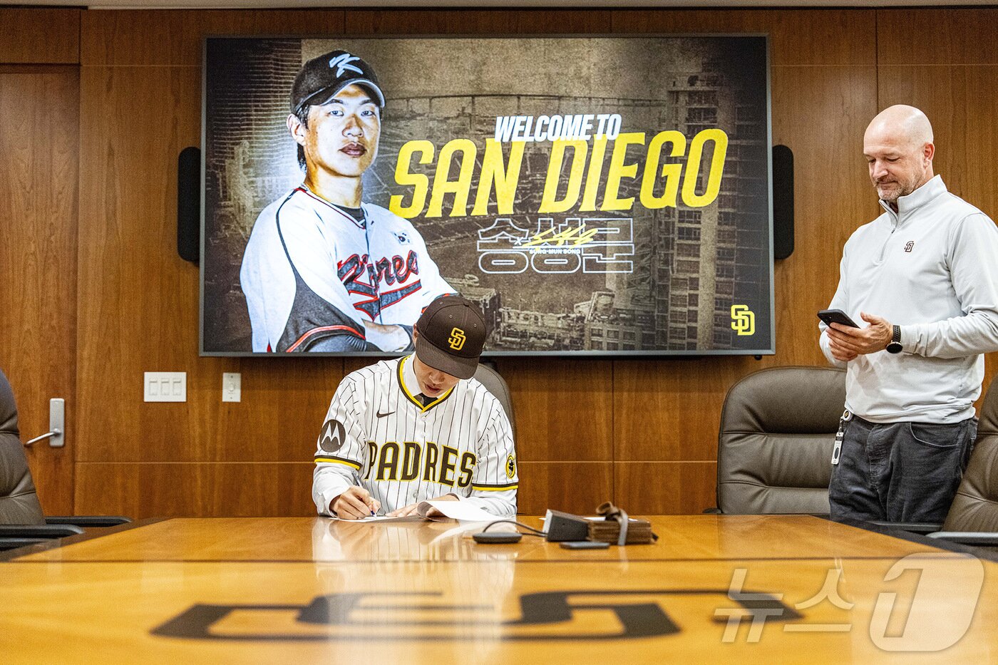 본문 이미지 - 미국 프로야구 메이저리그(MLB) 샌디에이고 파드리스가 23일(한국시간) 송성문 영입을 공식 발표했다. 사진은 샌디에이고 파트리스 유니폼을 입고 계약서에 서명하는 송성문. (키움 히어로즈 제공. 재판매 및 DB금지) 2025.12.23/뉴스1