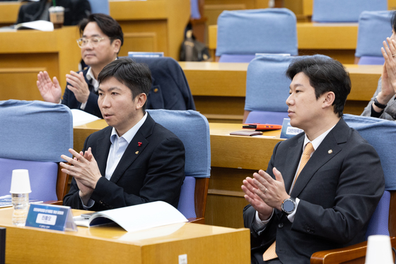 나란히 앉아 박수 치는 유승민 회장과 진종오 의원